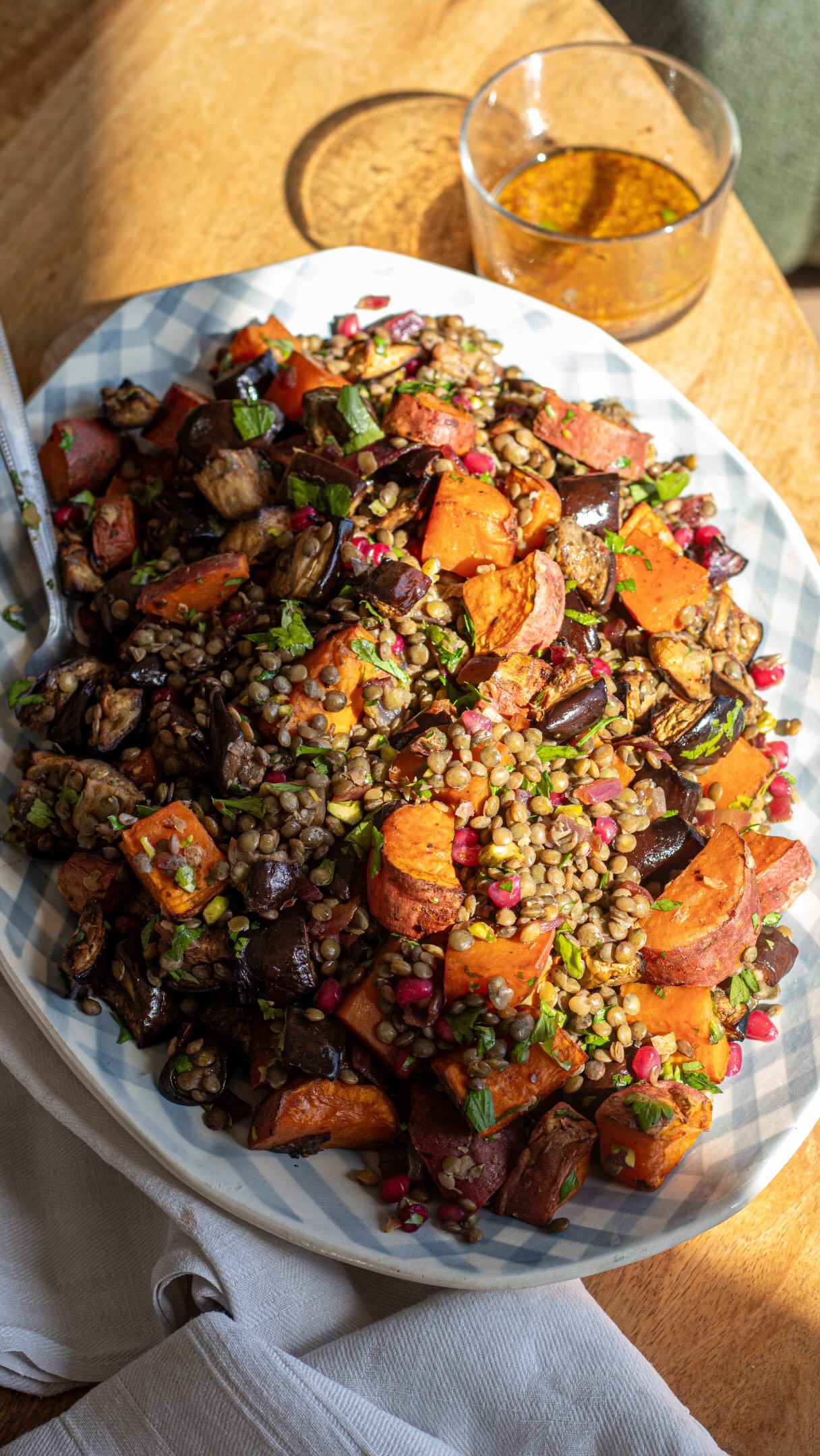 Salade de lentilles, patates douces et aubergines rôties : le plat complet qui a tout bon👉🏻astuces sur la cuisson des lentilles sur mesbrouillonsdecuisine.frPour les légumes rôtis
750 g de patate douce
4/5 petites aubergines ou 2 grosses
1 oignon
2 c. à soupe d’huile d’olive
1 c. à soupe de mélasse de grenadePour la salade
350 g de lentilles vertes cuites
2 c. à café de zaatar
1 c. à café de sumac
sel/piment d’Espelette
persil et coriandre
des graines de grenade surgelées
30g de pistachesPour la sauce
1,5 c. à s d’huile d’olive
1,5 c. à s de vinaigre balsamique
1,5 c. à s de jus de citron
1,5 c. à s d’eau
1 c. à s rase de moutarde à l’ancienne👉🏻 Précision : on n’est pas au gramme près ; quand je note pour 4 pers, c’est selon les appétits et l’activité de chacun (chez nous, on est de gros mangeurs, alors on est souvent plus proche de 3 que de 4).Coupez les aubergines et les patates en cubes et répartissez-les dans un plat avec l’oignon rouge émincé. Arrosez d’huile d’olive, mélasse de grenade, puis zaatar, sumac, sel et piment d’Espelette. Mélangez bien.
Enfournez pour 40 à 45 minutes à 200 °C, en mélangeant une fois ou deux pendant la cuisson. Le temps de cuisson peut varier selon les fours : les légumes doivent être bien fondants et légèrement caramélisés. Une fois vos légumes cuits et à la sortie du four, goûtez et rectifiez l’assaisonnement si besoin. Ajoutez lentilles cuites, persil et coriandre ciselés, graines de grenade et pistaches concassées. Préparez la sauce en mélangeant l’huile d’olive, le vinaigre balsamique, le jus de citron, l’eau et la moutarde à l’ancienne. Versez sur la salade, mélangez bien et servez directement.