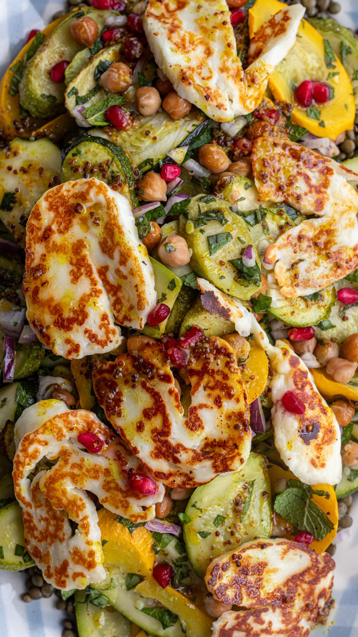 Salade de lentilles, halloumi, courgettes, pois chiches rôtis  👉🏻 Astuces sur la cuisson des lentilles sur le blog mesbrouillonsdecuisine.fr  👉🏻Vous pouvez la manger tiède ou froide, et elle se conserve 3 jours au frigo. Ajouter la sauce et halloumi au dernier moment si possible.  👉🏻L’astuce pratique : conserver la grenade au congélateur pour profiter de sa saveur et de son croquant à tout moment. Vous en trouverez chez Picard si vous n’avez pas envie de l’égrainer vous-même.  Pour 3 personnes : 
765 g de courgettes (pesées entières)
100 g de pois chiches en boite
350g de lentilles cuites (150g crues)
150 g de halloumi
1 petit oignon rouge
Quelques grains de grenade (facultatif)
1 beau bouquet de menthe et basilic fraîs
Huile d’olive/Sel/poivre  Pour la sauce :
1 c. à soupe de miel
2 c. à soupe de jus de citron
2 c. à soupe d’huile d’olive
1 c. à soupe d’eau
1 c. à soupe de moutarde à l’ancienne
1/2 c. à café de curcuma
poivre et un peu de sel  Coupez les courgettes en fines tranches en biais pour obtenir de jolies lamelles. Disposez-les dans un grand plat avec les pois chiches. Ajoutez un généreux filet d’huile d’olive, mélangez bien et enfournez pendant 25 minutes à 200 degrés en mélangeant une fois en cours de cuisson.
Pour la sauce, mélangez tous les ingrédients. 
Une fois les courgettes et les pois chiches rôtis, laissez tiédir avant d’ajouter l’oignon rouge, la menthe et le basilic. Poivrez et mélangez.
Faire griller le halloumi en tranches dans une poêle bien chaude, sans matière grasse, quelques minutes. Dans un grand plat de service, répartissez les lentilles bien froides. Disposez vos légumes rôtis puis les tranches de halloumi. Ajoutez quelques grains de grenade pour une touche colorée et fraîche. Versez généreusement la sauce sur l’ensemble.  #salad #lentils #halloumi